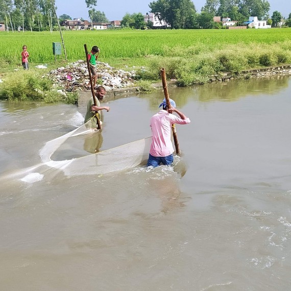 नालामा माछा मार्दै स्थानीय